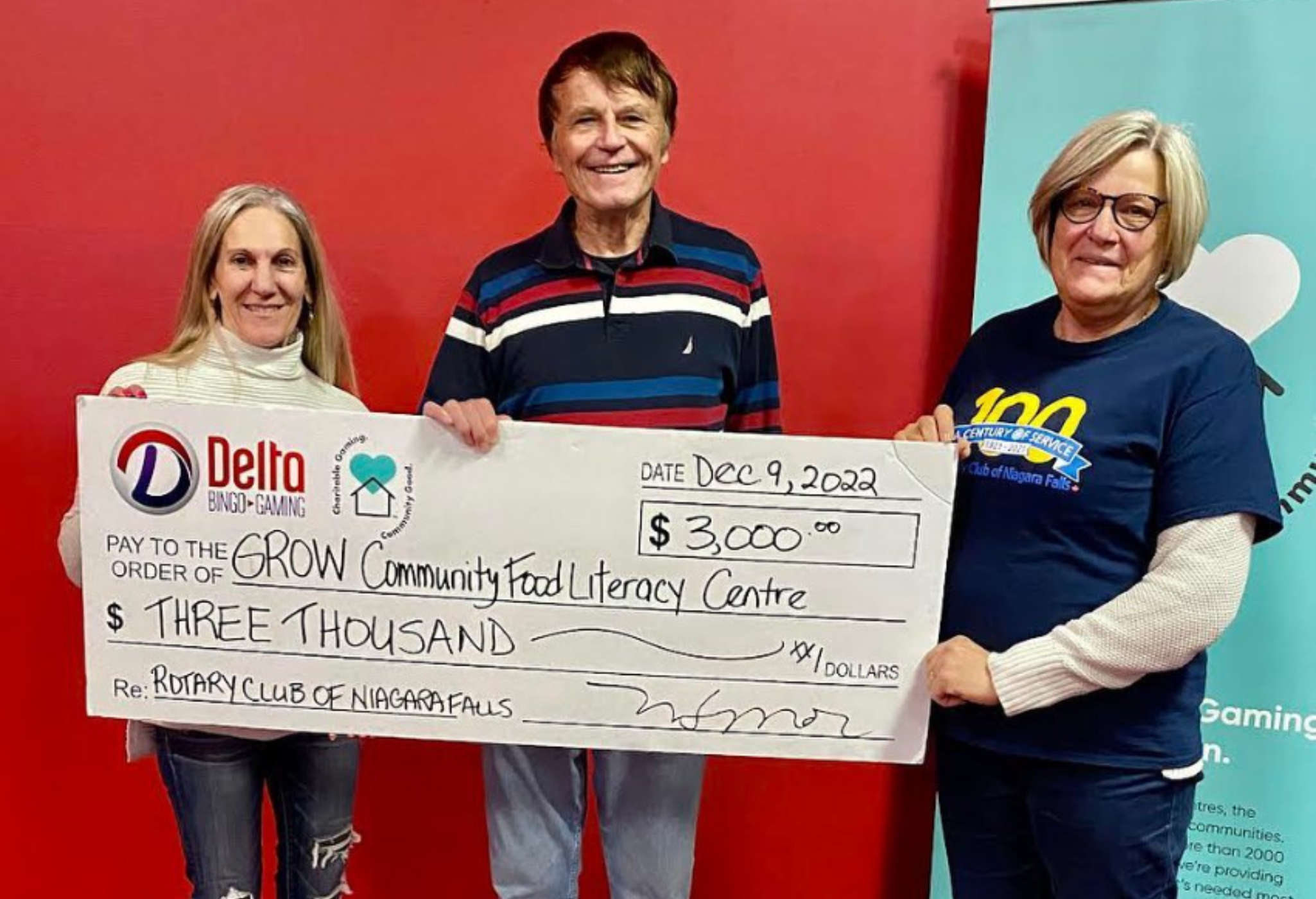 Rose avec deux bénévoles du Rotary Club de Niagara Falls. Les trois sourient et tiennent un chèque géant de 3 000 $ au profit du Grow Community Food Literacy Centre.