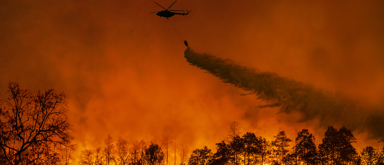 Helicopter spraying water onto forest fire - Un hélicoptère pulvérise de l'eau sur un feu de forêt